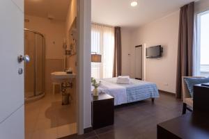 里米尼格米酒店的客房内的浴室设有床和水槽