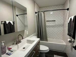 奥尔巴尼Downtown Albany 1 Bed + Workstation @ Maiden Lane的浴室配有盥洗盆、卫生间和浴缸。