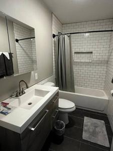 奥尔巴尼Downtown Albany 1 Bed + Workstation @ Maiden Lane的浴室配有盥洗盆、卫生间和浴缸。