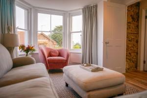 海景城Jumble Cottage的带沙发、椅子和窗户的客厅