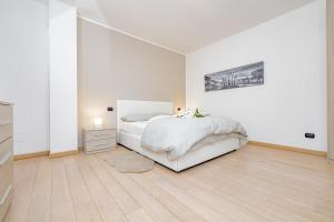 阿萨哥Milan Forum Camelia Guesthouse的一间白色卧室,配有一张床和一个梳妆台