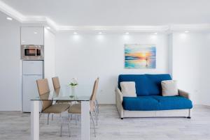 阿罗纳Fantastic Apartment las americas heart的客厅配有蓝色的沙发和玻璃桌