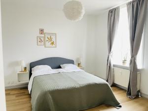 约灵aday - The Swanky Suite的白色卧室配有一张带绿毯的床