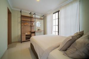 巴淡岛中心Danka@tudor residence的一间卧室设有一张大床和一个窗户。