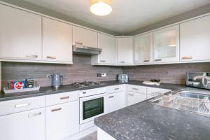 LincolnshireKime Contractor & Holiday Home的厨房配有白色橱柜和台面