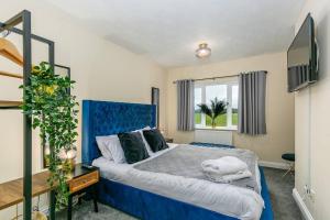 LincolnshireKime Contractor & Holiday Home的一间卧室设有蓝色的床和窗户。