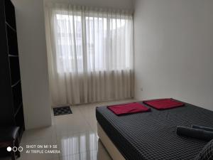 日得拉Pool Smart Tv Wifi 3 aircond room Jitra Kolej Height Utara的一间卧室配有一张带两个红色枕头的床