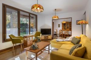 哈卡Villa Lana chalet Baros, Jaca的客厅设有黄色沙发和电视