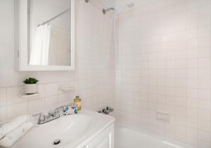 纽约Beautiful Studio Apartment At East Side的白色的浴室设有水槽和镜子