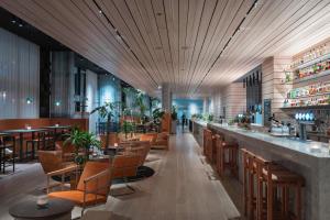 斯德哥尔摩北欧之光酒店的餐厅设有长长的酒吧,配有桌椅