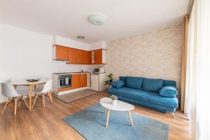 布达佩斯Nova Apartments的客厅配有蓝色的沙发和桌子