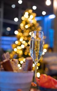 根特诺富特根特中心酒店的酒杯坐在桌子上,后面有圣诞树