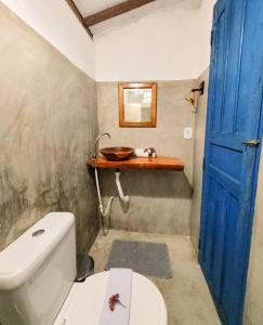 卡拉伊瓦Pousada Vilarejo的浴室设有白色卫生间和蓝色门。