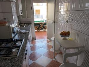 蓬塔翁布里亚Casa Delfin的厨房配有一张桌子,上面放着一碗水果