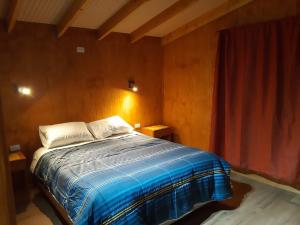 富伊港Cabañas Raulies, Neltume.的一间卧室配有床和红色窗帘