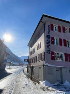 沃尔芬希森Alpina Einhorn - Self-Check-In的雪中,太阳在背后的建筑