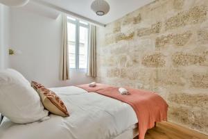 波尔多Nocnoc - Le Balcon de l'Oli 99m2的卧室配有白色的床和砖墙