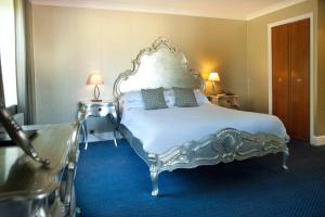埃克塞特Woodbury Park Hotel & Spa的卧室配有白色大床和蓝色地毯