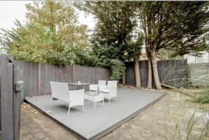 伦敦London comfy doubles的庭院配有白色的椅子和桌子,设有围栏