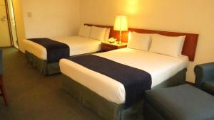 墨西哥城布里斯托酒店的酒店客房,配有两张床和椅子