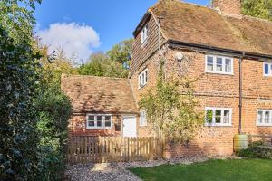 坎特伯雷Host & Stay - Bere Cottage的一座古老的红砖房子,设有木栅栏