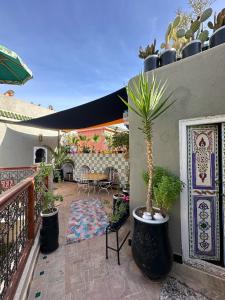 马拉喀什本萨利赫摩洛哥传统庭院住宅的一个带桌子和盆栽的庭院