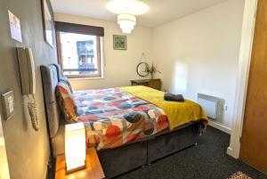 考文垂Gorgeous Modernised City Centre Apartment的一间卧室配有一张带五颜六色棉被的床