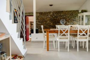 塞亚Quinta da Cerdeira的一间带木桌和白色椅子的用餐室
