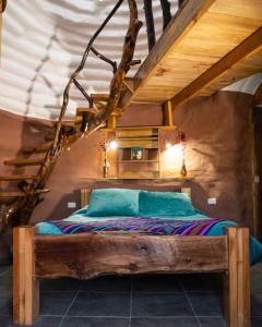 圣佩德罗·德·阿塔卡马DOMOS PUJLLAI San Pedro de Atacama的阁楼卧室配有木床