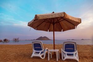 阿布辛贝Habib Camp的海滩上的两把椅子和一把遮阳伞