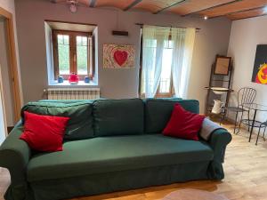CastañerasEL CAMPIZO的客厅里配有绿色沙发,提供红色枕头