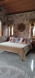 穆库热Oforasteiro的卧室配有一张石墙内的大床
