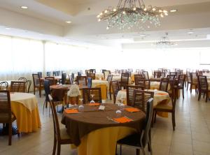 Casa dello StumioVillaggio Club Baia Dei Gigli的一间带桌椅和吊灯的用餐室