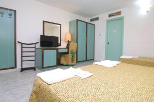 Casa dello StumioVillaggio Club Baia Dei Gigli的酒店客房设有两张床和电视。