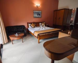 卡兰古特Renzo's Inn的一间卧室配有一张床、一张沙发和一张桌子