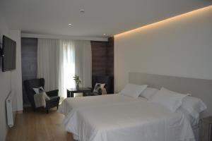 普韦布拉桑纳比亚维多利亚酒店的卧室配有白色的床和2把椅子