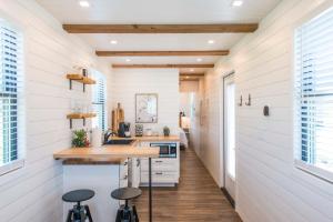 BellmeadThe Meadows Shipping Container Home的一间铺有木地板的白色墙壁厨房