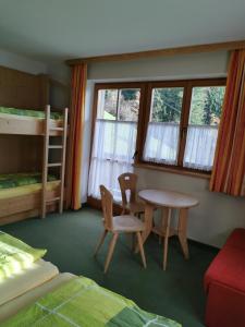 施图默尔贝格Gästehaus Bonholz的一间卧室配有桌椅和双层床