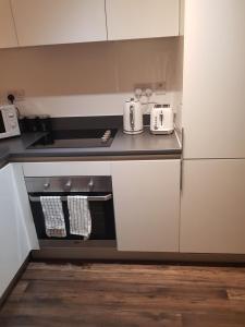 达德利Stunning 1-Bed Apartment in Brierley Hill的厨房配有白色橱柜和台面
