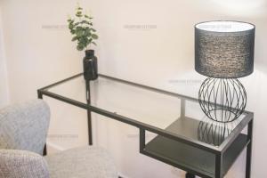 阿伯丁Riverside Drive Apartment - Grampian Lettings Ltd的玻璃桌,带灯和椅子