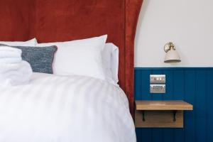 KnebworthThe Chequers Inn的卧室配有白色的床和边桌