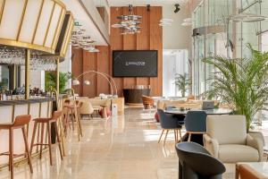 埃斯托利尔EVOLUTION Cascais-Estoril Hotel的餐厅设有酒吧和桌椅