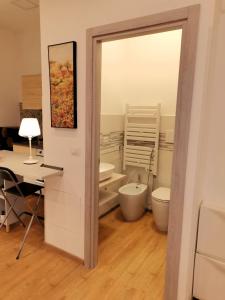 博洛尼亚La Ca' Pezzana Affittaly Apartments的一间带卫生间和水槽的浴室以及一张书桌。