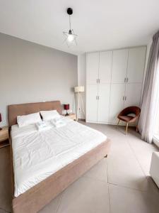 雅典Gladiolus ANhome Premium Selections的白色卧室配有一张大床和椅子