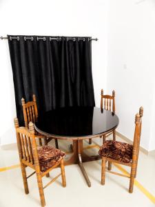 科钦The Chill House的桌子和两把椅子以及窗帘