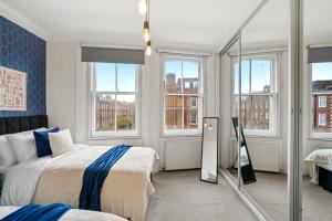 伦敦Delightful Flat in London - Sleeps 6的一间卧室配有两张床和镜子
