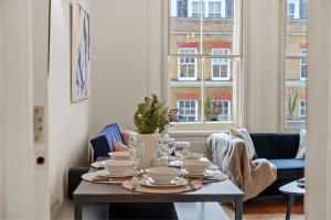 伦敦Delightful Flat in London - Sleeps 6的一间用餐室,配有餐桌和餐具