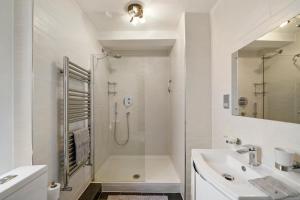伦敦Delightful Flat in London - Sleeps 6的带淋浴和盥洗盆的白色浴室