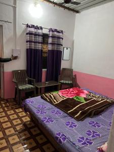 布什格尔Baba hostel的一间卧室配有一张床、两把椅子和一张桌子