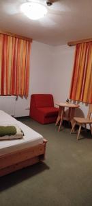 施图默尔贝格Gästehaus Bonholz的一间设有两张床和一张红色沙发的房间